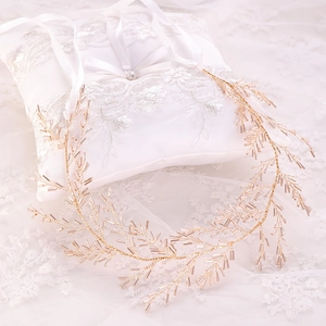 Détail du bandeau de mariée fait main en fil doré avec perles rose champagne sur dentelle