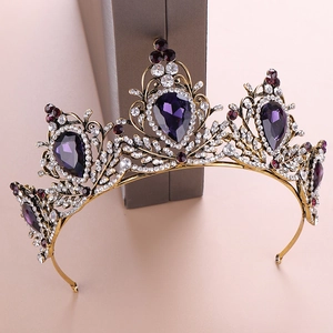 Detail of vintage gold baroque crown with purple crystals and white rhinestones