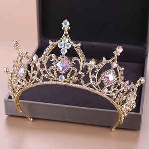 Golden baroque crystal crown with iridescent AB stones on a grey jewelry display box