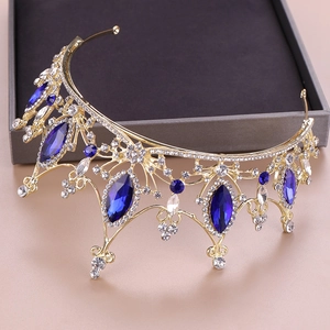 Dettaglio della tiara dorata decorata con pietre blu scuro e cristalli scintillanti
