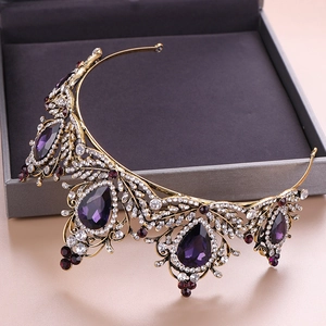 Detail of baroque vintage crown with purple crystals and antique gold leaf patterns