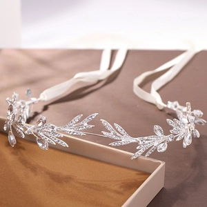 Close-up of silver bridal leaf headband with crystals and white ribbon tie