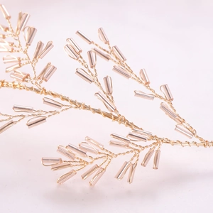 Détail du serre-tête de mariée en fil doré fait main avec perles de cristal rose
