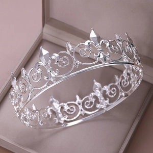Detail view of silver crown with intricate scrolling patterns in a jewelry box
