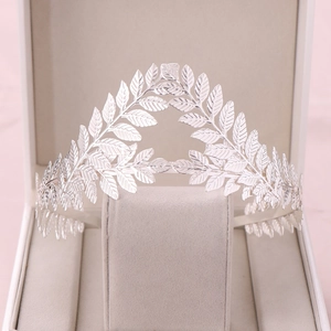 Close-up of elegant silver vintage leaf crown on beige velvet jewelry stand