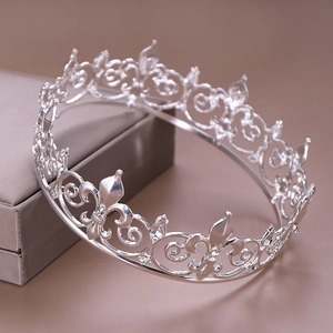 Detailed close-up of a silver bridal crown with intricate filigree and sparkling rhinestones