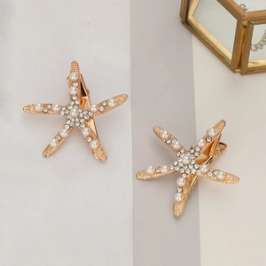 Détail de barrettes étoile de mer avec base dorée, perles blanches et cristaux