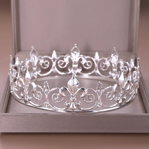 Detailed macro of a silver crown with fleur-de-lis patterns in a premium gift box