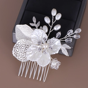 Détail macro d'un peigne de mariée avec perles, fleur en cristal et feuilles filigranées