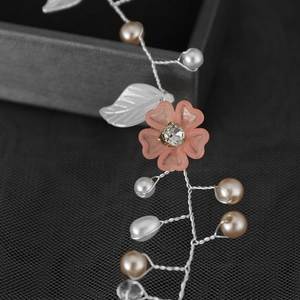 Détail macro d'un bandeau fleur rose fait main avec des cristaux et des perles
