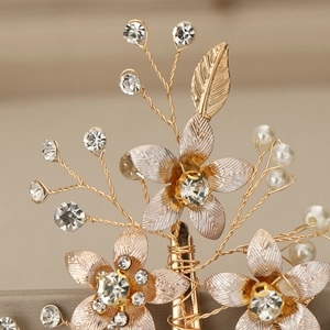 Gros plan détaillé de la pince à cheveux mariée dorée avec strass brillants et perles