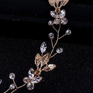 Gros plan détaillé du bandeau doré avec feuilles en métal et strass pour la mariée