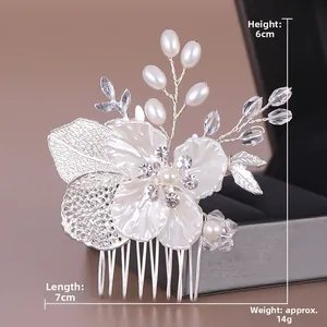 Détail du peigne à cheveux de mariée avec pétales blancs, feuilles argentées et perles