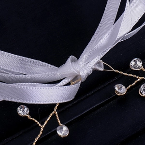 Détail du bandeau de mariée avec ruban de satin blanc et strass en cristal sur fil doré