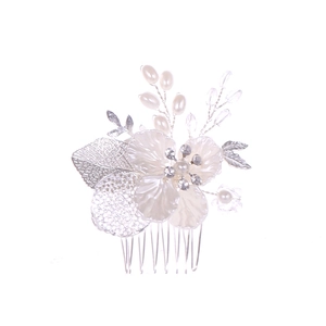 Détail du peigne de mariée avec fleurs blanches, feuilles argentées, perles et cristaux