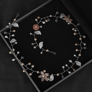 Détail de vigne à cheveux mariée avec fleurs roses, perles et strass sur velours noir