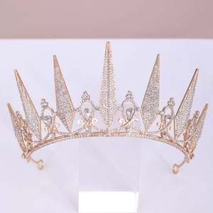 Macro detail of royal crystal tiara with golden finish and pear-shaped white gemstones