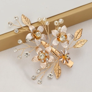 Vue détaillée de la pince à cheveux fleur dorée avec perles et cristaux scintillants
