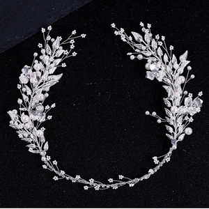 Silver bridal hair band with white pearls and metal leaves on black background