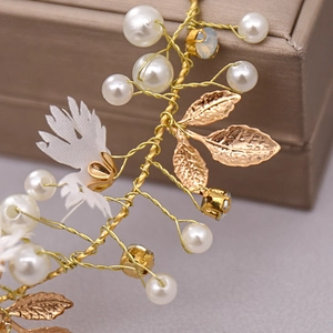 Close-up of golden leaf hairband with white pearls and sparkling crystal details