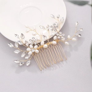 Détail d'un peigne de mariée fait main avec fils dorés, perles et fleurs en cristal