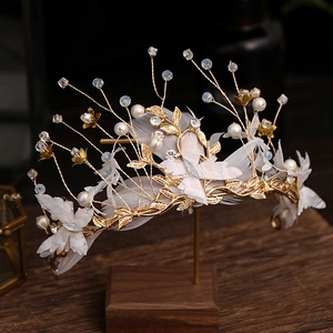 Detail of handmade gold bridal tiara with lace butterflies, feathers and pearls