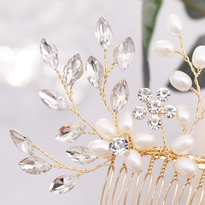 Vue macro d'un peigne à cheveux en fil d'or avec feuilles de cristal et perles blanches