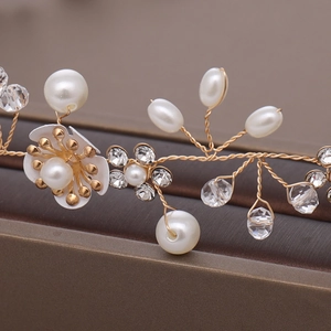 Detailed close-up of handmade bridal headband with pearls and gold wire flowers