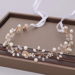 Handmade bridal headband with white pearls, crystals and flowers on a vintage tray