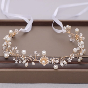 Detail of bridal headband with gold wires, white pearls, crystals and fabric flowers