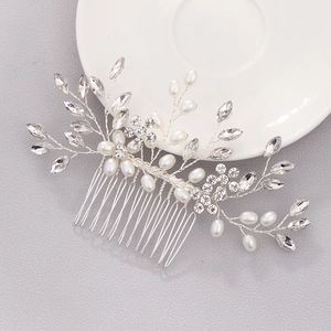 Détail de peigne à cheveux de mariée avec perles et strass marquise sur un plat céramique