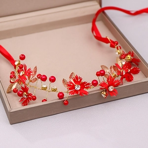Detailed close-up of handmade bridal headband with red flowers, pearls and golden leaves