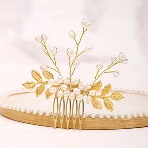 Dettaglio del pettine per capelli da sposa con foglie dorate, perle e cristalli