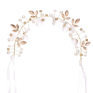 Elegant gold bridal headband with fabric flowers, pearls, and leaf accents on white silk ribbon