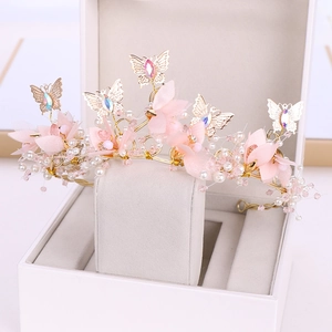 Détail de la couronne papillon rose avec fil doré, fleurs en mousseline et perles en boîte