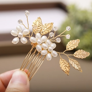 Détail d'un peigne de mariée avec feuilles dorées, perles et tissage artisanal chic