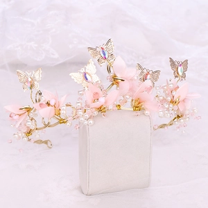 Détail de serre-tête de mariée avec fleurs roses et papillons dorés faits à la main