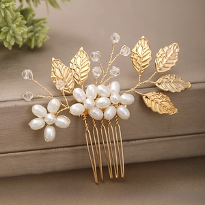 Détail du peigne à cheveux avec feuilles, perles et fil doré sur un fond marron