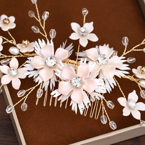 Gros plan d'un peigne à cheveux de mariée avec fleurs roses et perles en cristal
