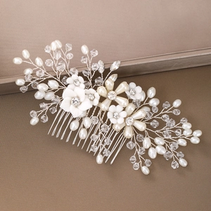 Dettaglio del pettine da sposa con fiori di ceramica bianca, perle e cristalli