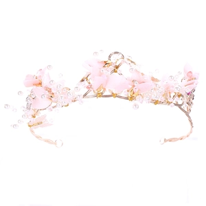 Couronne de mariée rose avec fleurs, fil doré, perles, cristaux et papillon sur blanc