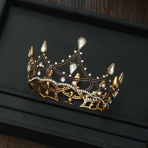 Macro shot of an antique gold baroque crown with intricate crystal embellishments