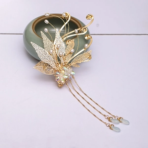 Detail of golden filigree leaf hairpin with pearls and delicate tassel chains