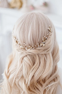 Dettaglio dell'accessorio sposa con foglie dorate e cristalli intrecciati nei capelli