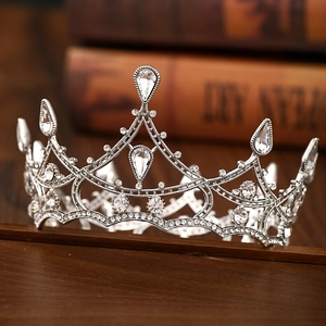 Close-up of intricate silver baroque bridal crown with crystal rhinestones on vintage books