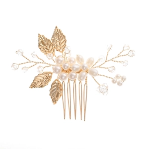 Peigne à cheveux de mariée avec feuilles dorées perles et cristaux sur fond blanc