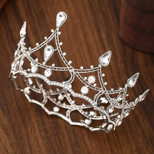 Baroque silver bridal tiara crown with sparkling crystals on a vintage wooden surface