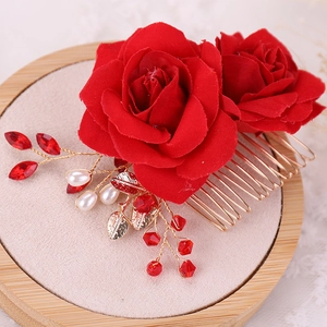 Close-up of handmade red fabric roses hair comb with golden leaves and white pearls
