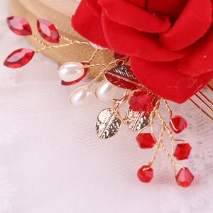 Macro detail of handmade red fabric rose hair comb with crystals and pearls