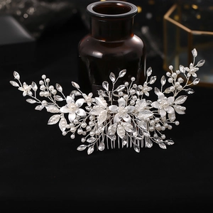 Détail d'un peigne à cheveux de mariée avec fil d'argent, perles blanches et strass brillants